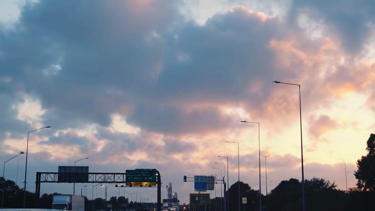 Traffico serale su un'autostrada affollata con tramonto nuvoloso