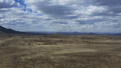 toma aérea lenta hacia atrás de un paisaje desértico nublado y cambiante en el karoo, sudáfrica