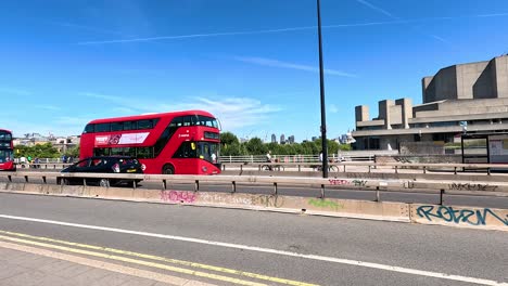 a bus travels past a cityscape in london