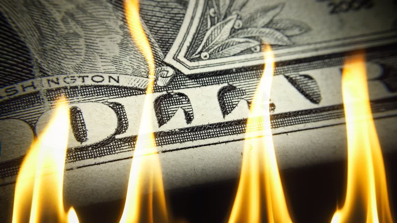 1 US dollar bill close-up on fire in flames on a black background . Conceptual 4k slow motion video. The idea of ​​a financial crisis.