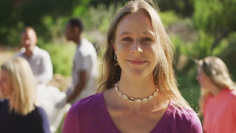 caucasian woman smiling and looking at camera during river clean-up day