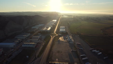 industrial park at sunrise with road and trucks