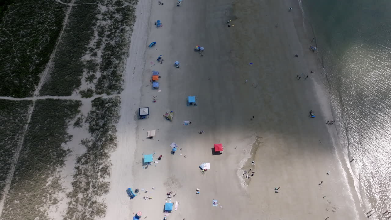 Aerial view of Hilton Head beach showing colorful umbrellas and tents scattered across the sandy shore