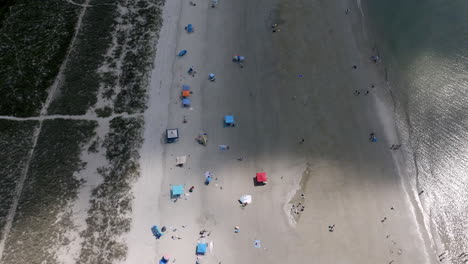 aerial view of hilton head beach showing colorful umbrellas and tents scattered across the sandy shore