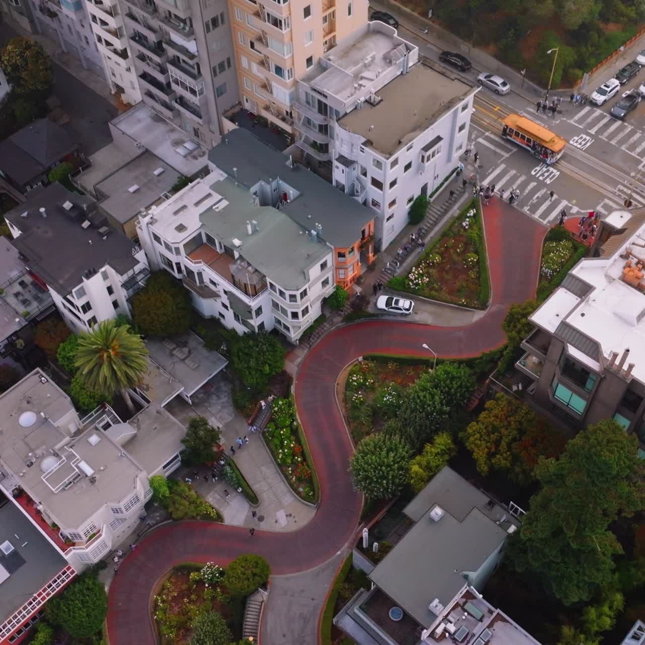 Descending through the thick fog over the beautiful city. Aerial footage over Lombard Street in San Francisco, California, USA