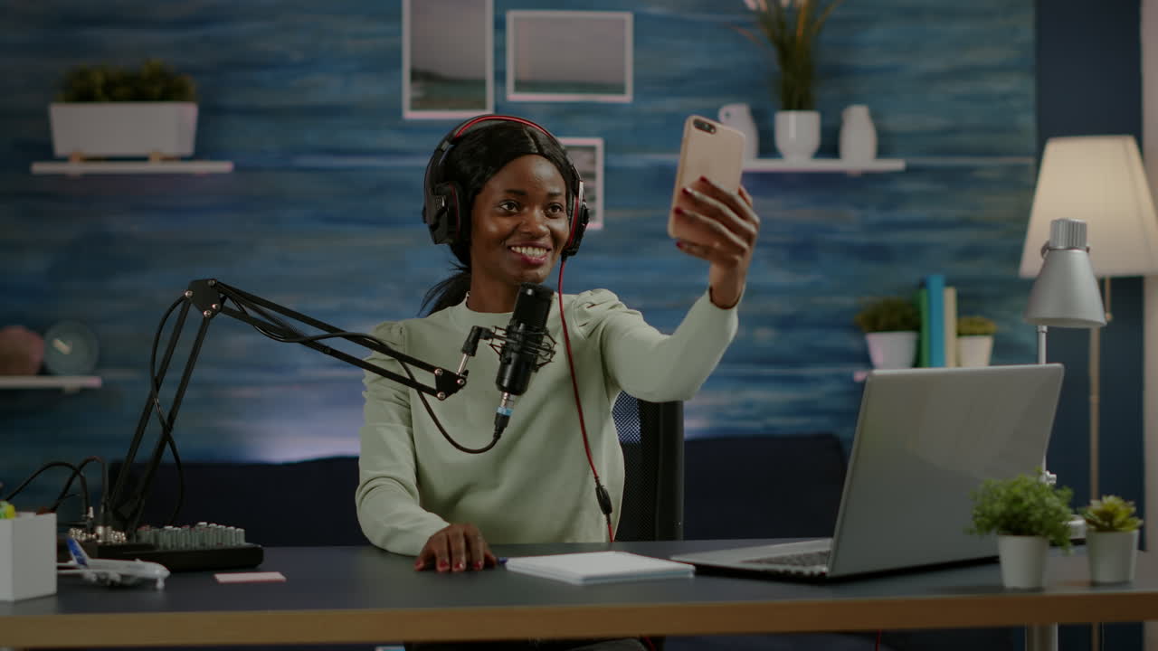 Donna africana che usa lo smartphone per scattare un selfie durante un podcast