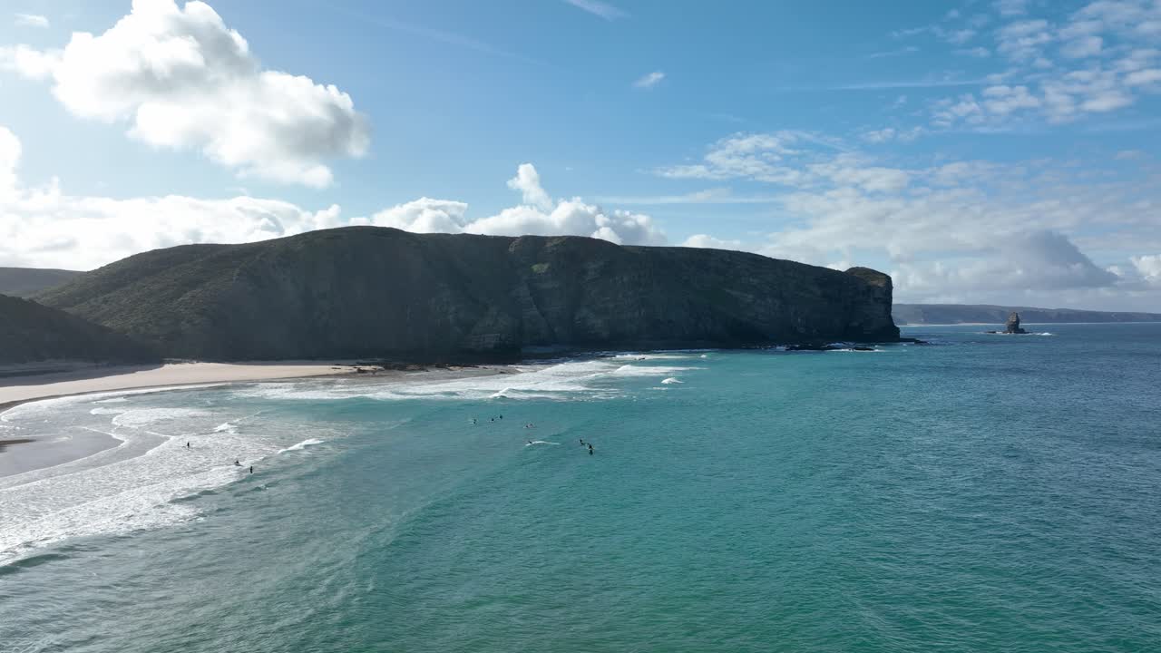 Wide aerial view of a beautiful beach and rugged cliffs along the Atlantic Ocean on a sunny day