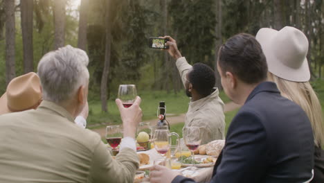 Gruppe-Von-Freunden-Mittleren-Alters,-Die-Während-Einer-Party-Im-Freien-Im-Park-Ein-Selfie-Am-Tisch-Machen