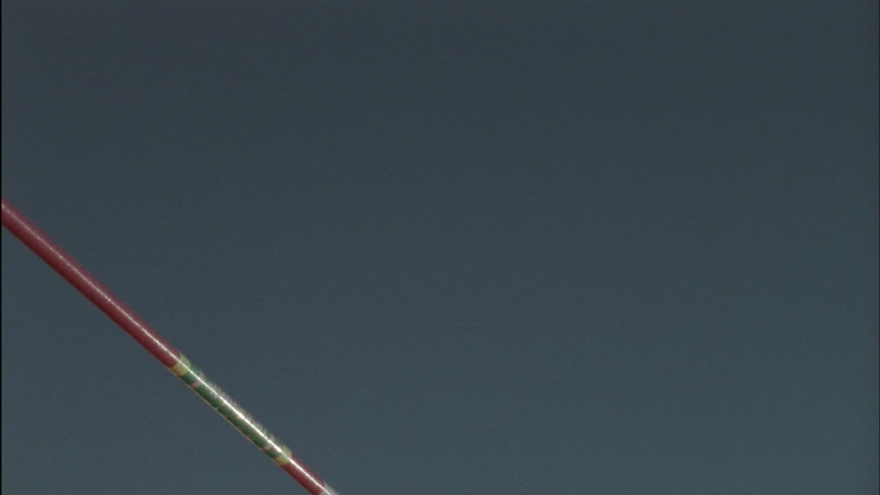 un hombre salta alto sobre una barra