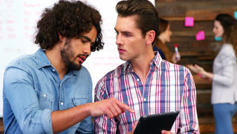 business executives discussing over digital tablet in meeting