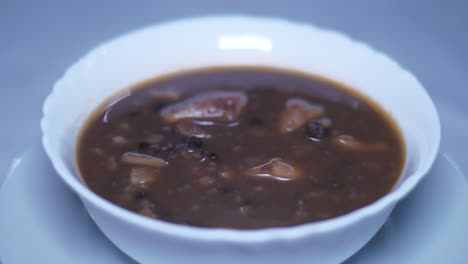 a black beans soup bowl rotating on a turning table