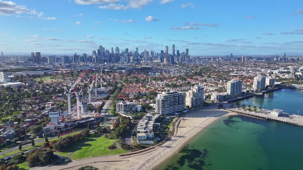 Aerial view of Port Melbourne beachfront suburb with Melbourne city skyline and active construction sites