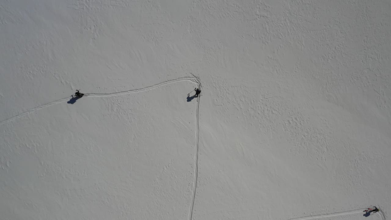 드론이 원을 그리며 회전하는 동안 스키를 타는 스키어의 오버헤드 드론 샷