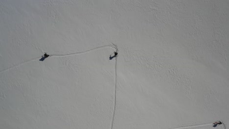 overhead drone shot of skiers skinning while drone rotates around in circle