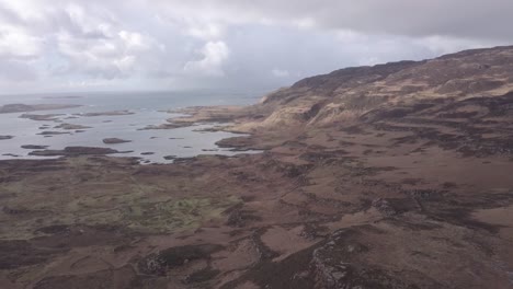 High-aerial-shot-slowly-decreasing-in-altitude-towards-the-hillside-and-archipelago-of-Ulva,-flying-in-a-westerly-direction,-towards-the-Atlantic-Ocean