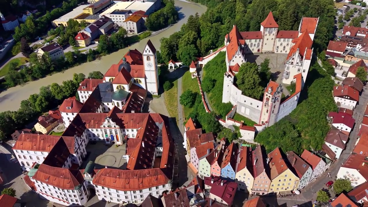 Veduta aerea con drone del castello Hohes Schloss, dell'Abbazia di St Mang e del centro storico lungo il fiume Lech, Füssen, Germania