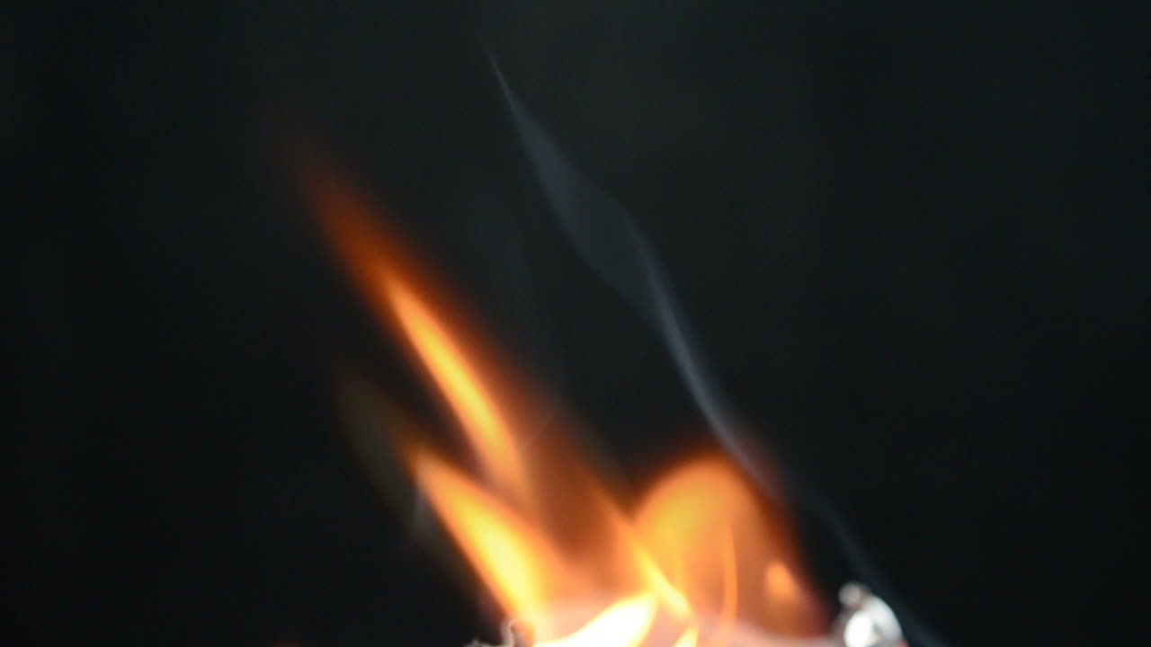 Slow Motion. Slowly burning fabric on a black background. Slow Motion. Slowly burning fabric