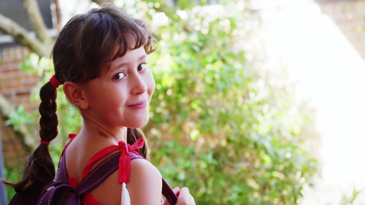 retrato de una estudiante feliz de pie en el campus en la escuela