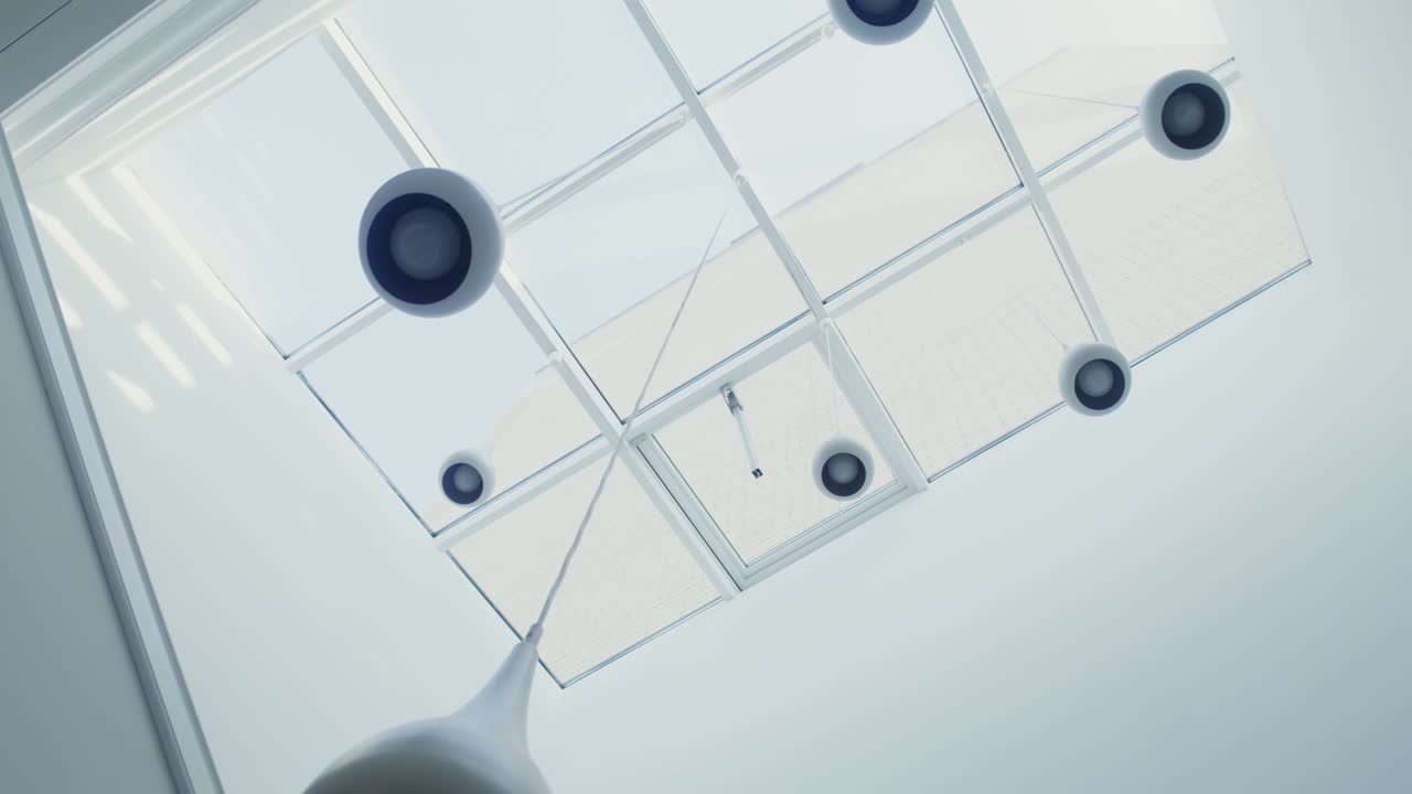 numerosos candelabros blancos cuelgan del techo de vidrio