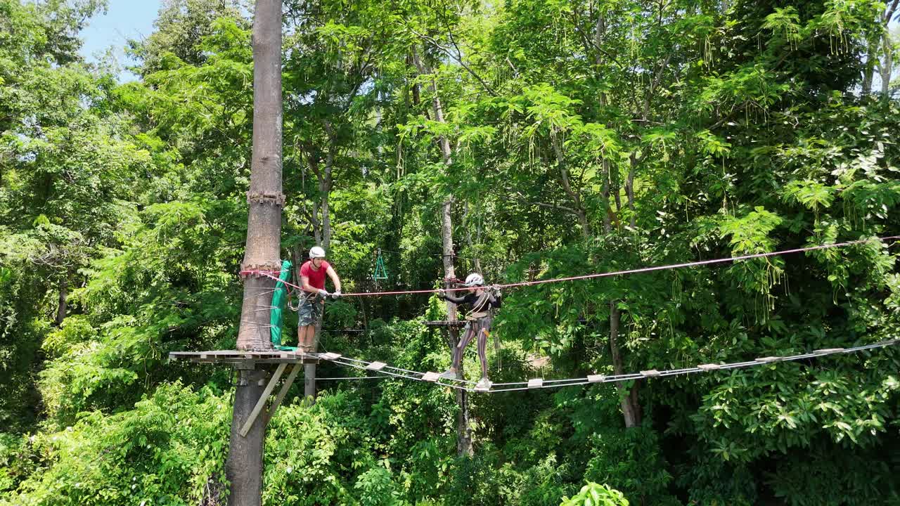 Couple enjoying a treetop adventure course