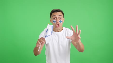 man cheering for finland screaming and waving a national flag