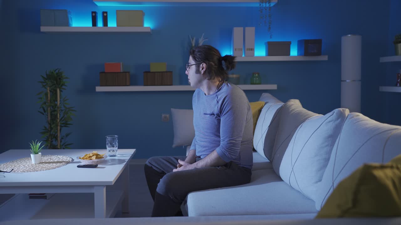 el hombre asustado en casa mira a su alrededor y se tensa.