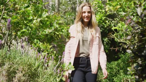 happy caucasian woman walking in garden on sunny day