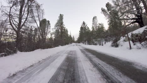 driving down a snowy road path trail fast motion in the mountains first person pov