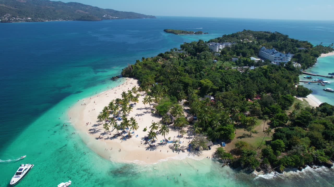 Vista aerea che circonda un'isola mozzafiato con una spiaggia e palme, uno scenario incredibile nella Repubblica Dominicana.