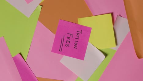 concepto educativo de notas adhesivas giratorias con tasas de matrícula escritas en la nota superior