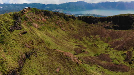 Drone-slowly-circles-around-the-crater,-on-top,-of-an-active-Asian-vulcano