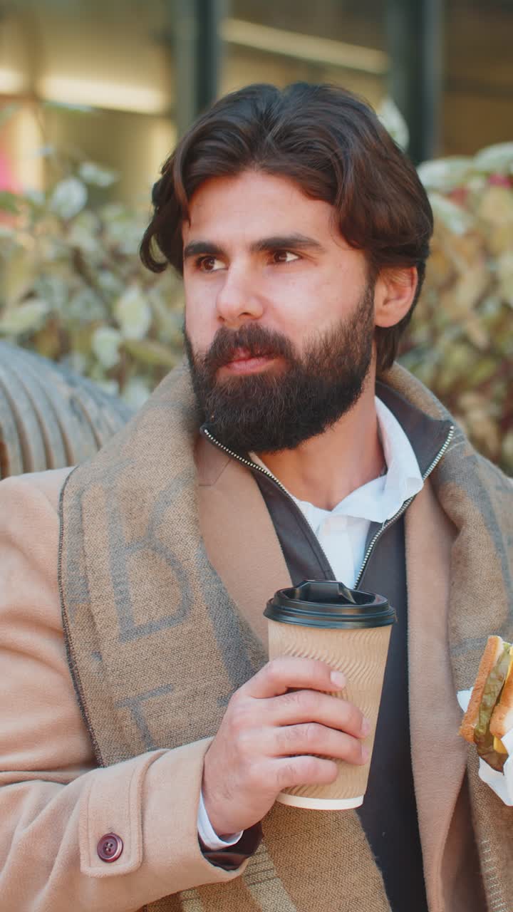 joven turista indio disfruta del almuerzo comiendo sándwiches y bebiendo café o té caliente
