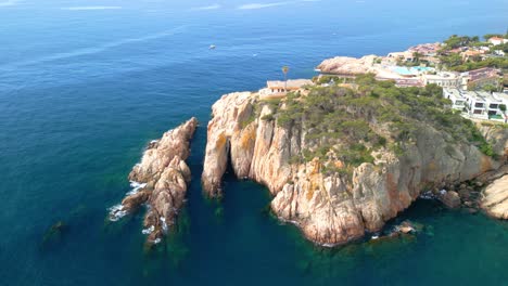 aerial perspective revealing sant feliu de guixols' dramatic coastal landscape, showcasing rugged rock formations, pristine turquoise waters, and elegant mediterranean seafront properties
