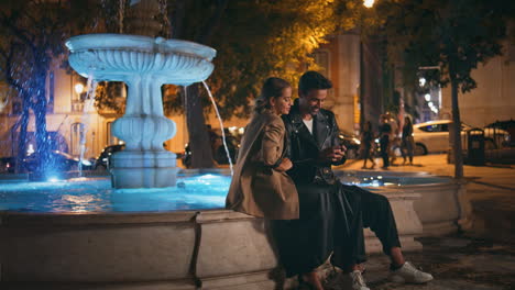 city couple taking selfie with smartphone. attractive lovers at fountain square