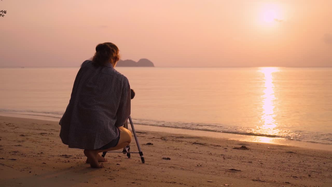 Woman taking a photo of a sunset at a beach