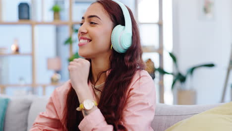 Headphones,-dancing-and-young-woman-on-a-sofa