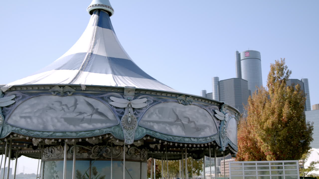 Carousel in downtown Detroit, Michigan with Renaissance Center in the background and video tilting up.