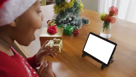 Mujer-Afroamericana-Con-Sombrero-De-Papá-Noel-Haciendo-Videollamada-Navideña-Con-Computadora-Portátil,-Con-Espacio-Para-Copiar-En-La-Pantalla