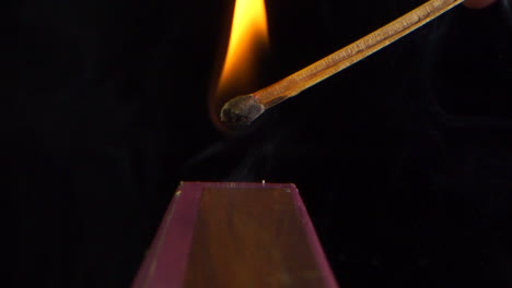 ignition and burning in slow motion of a match on the side of the box, black background