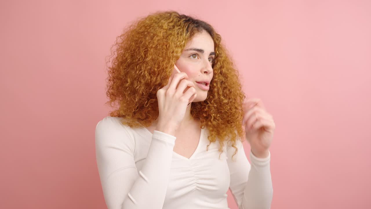 Young woman having various phone conversations on pink background
