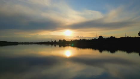 Luftaufnahme-Des-Sonnenuntergangshimmels-Am-Ufer-Des-Flusses-Daugava,-Sonnenlichtreflexion-Auf-Dem-Wasser,-Daugavpilsn,-Lettland