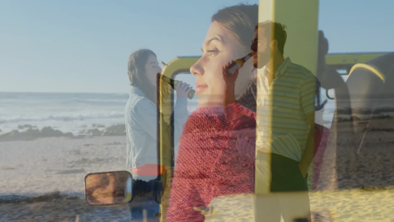 Applying makeup, woman on beach near couple enjoying view by yellow vehicle