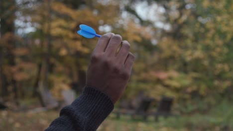 close up of a black man's hand as he throws a dart