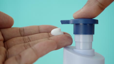 hand applying lotion from pump bottle