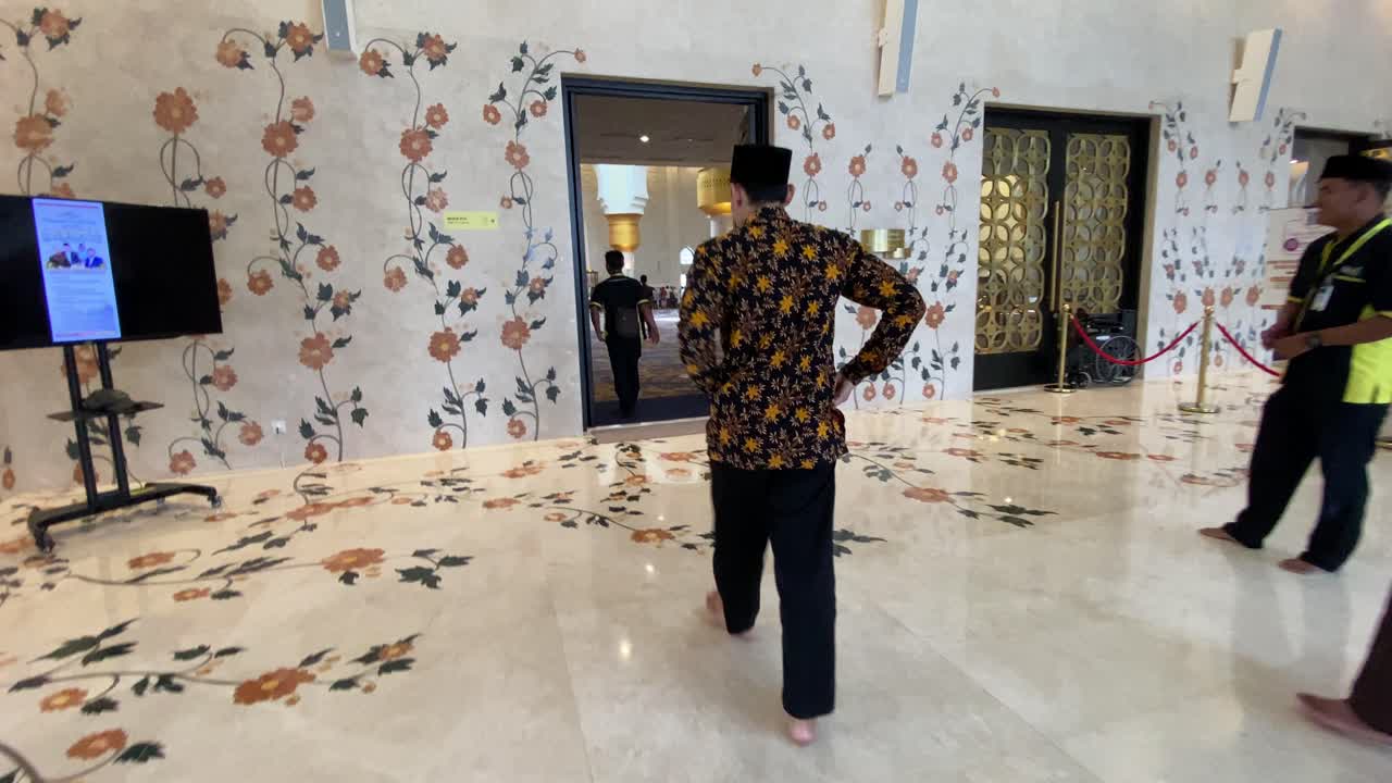 Worshippers walk into the door towards the line of worshippers who will perform prayers, at the Sheikh Zayed Grand Mosque in Surakarta, Indonesia