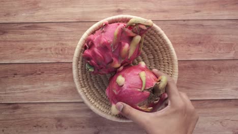 dragon fruit in a basket on a wooden table