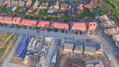 aerial top-down drone shot slowly descending above a residential construction site beside completed houses with gardens in wombwell, south yorkshire, england