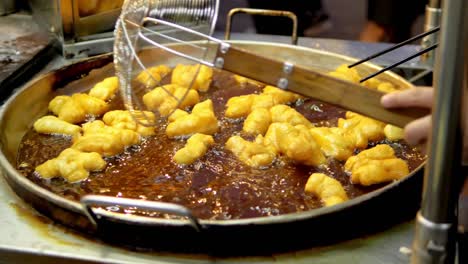 frying deep-fried dough stick in the pan at yaowarat road chinatown, a popular travel destination in bangkok, thailand