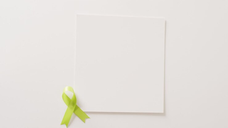 Video of pale green std awareness ribbon and white card with copy space, on white background