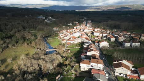 retirada aérea a lo largo del río por encima de la pintoresca aldea española en el campo